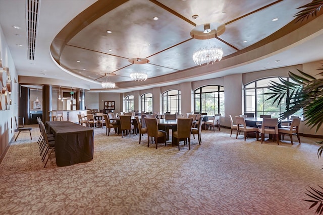 dining room featuring a tray ceiling, light colored carpet, and an inviting chandelier