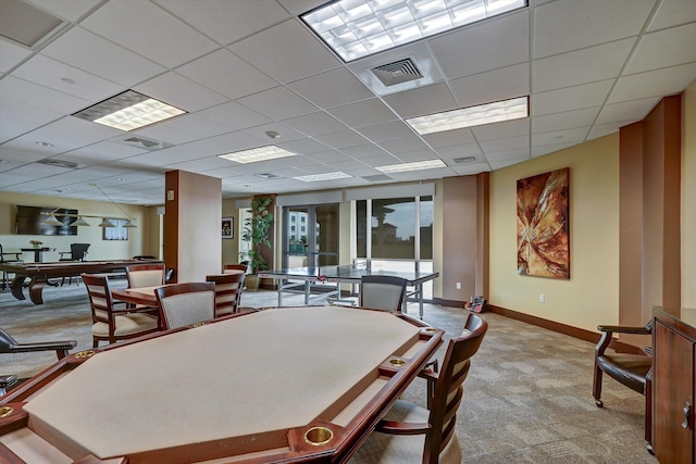 carpeted dining room with a drop ceiling