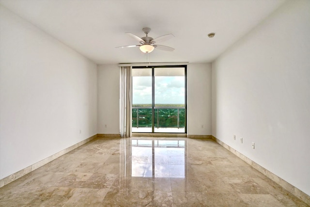 unfurnished room featuring a wall of windows and ceiling fan