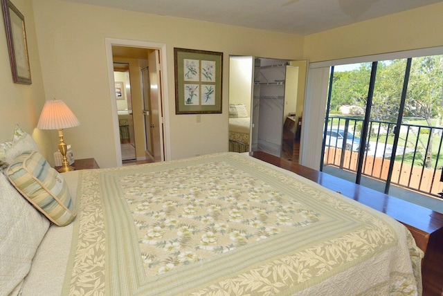 bedroom with a walk in closet, ensuite bath, access to outside, wood-type flooring, and a closet