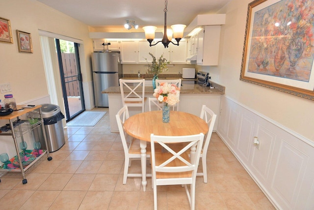 tiled dining area featuring a chandelier