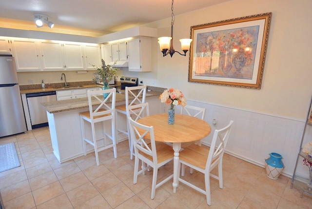 dining space with a chandelier, light tile patterned floors, and sink