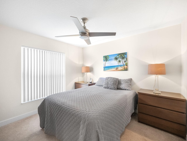 bedroom with ceiling fan and light carpet