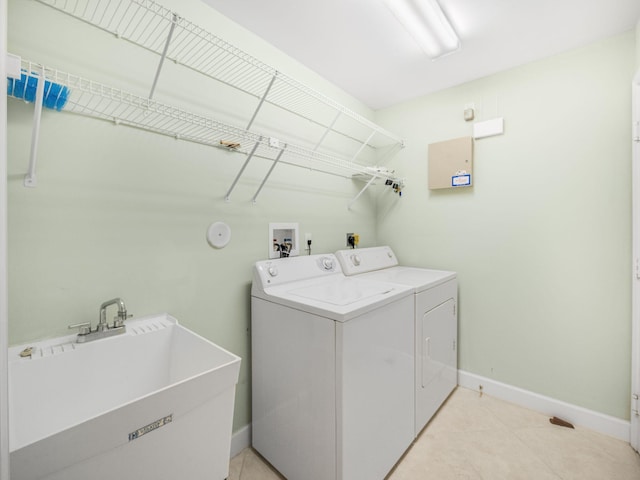 clothes washing area with washing machine and dryer and sink