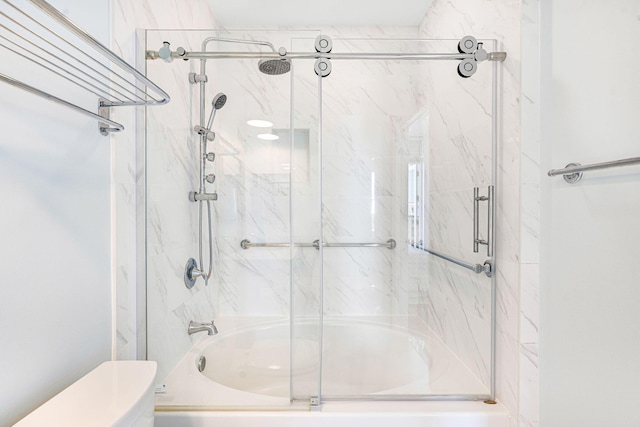 bathroom with enclosed tub / shower combo and toilet