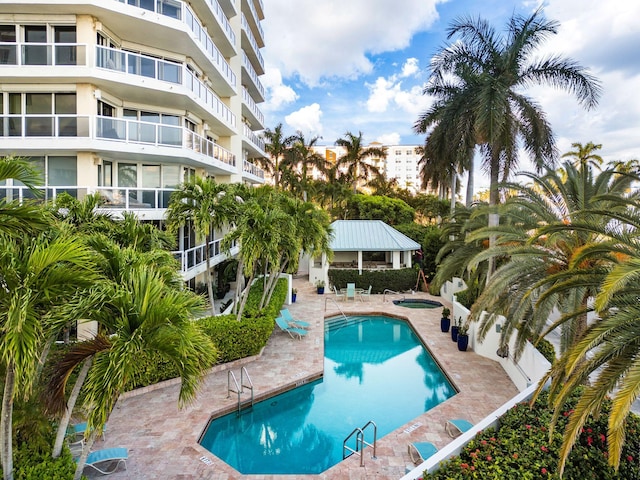 view of swimming pool featuring a community hot tub and a patio