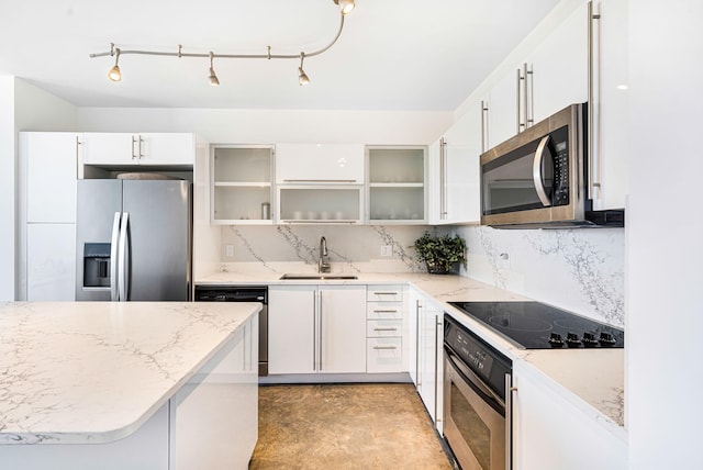 kitchen featuring sink, white cabinetry, light stone counters, tasteful backsplash, and black appliances