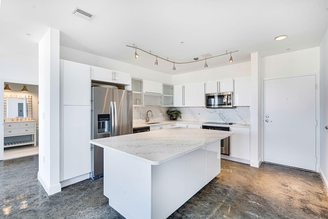 kitchen with tasteful backsplash, white cabinetry, appliances with stainless steel finishes, and sink