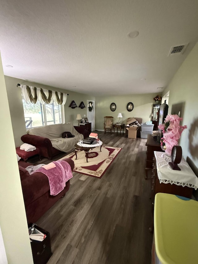 living room with a textured ceiling and dark wood-type flooring