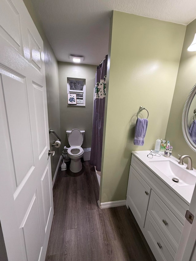 bathroom with toilet, hardwood / wood-style floors, vanity, and a shower with shower curtain