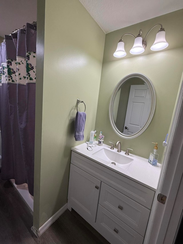 bathroom featuring hardwood / wood-style flooring, vanity, a shower with curtain, and a textured ceiling