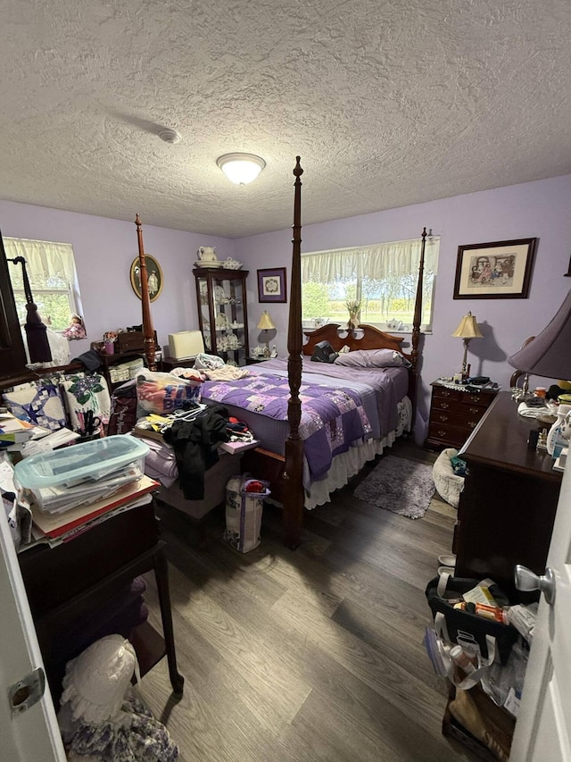 bedroom featuring hardwood / wood-style flooring and a textured ceiling