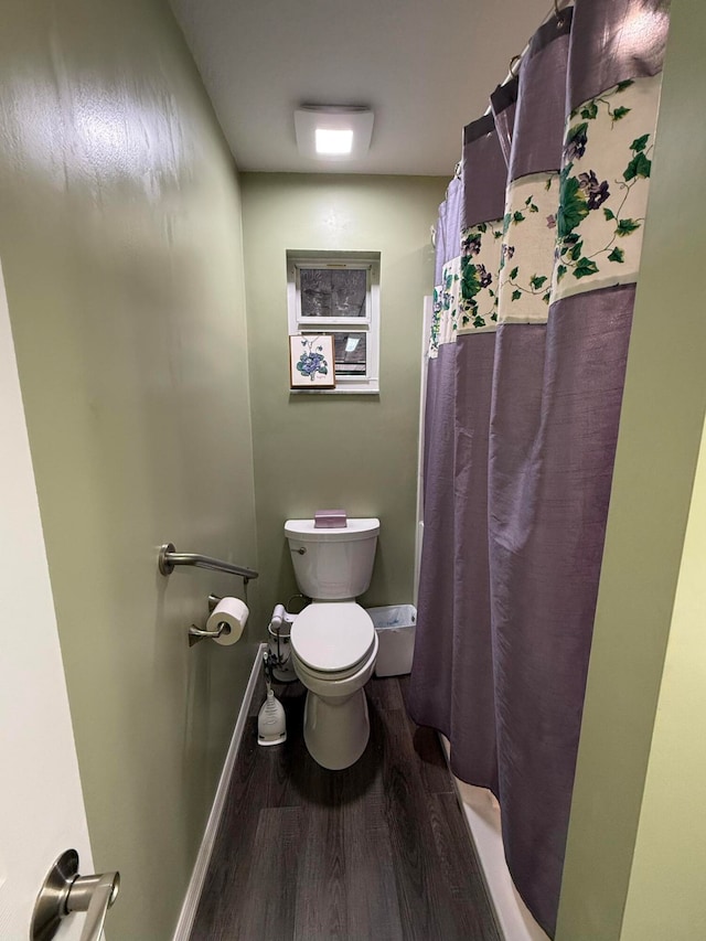 bathroom featuring a shower with shower curtain, hardwood / wood-style floors, and toilet