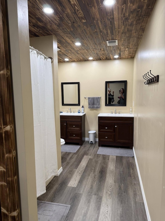 bathroom with hardwood / wood-style floors, vanity, and wooden ceiling