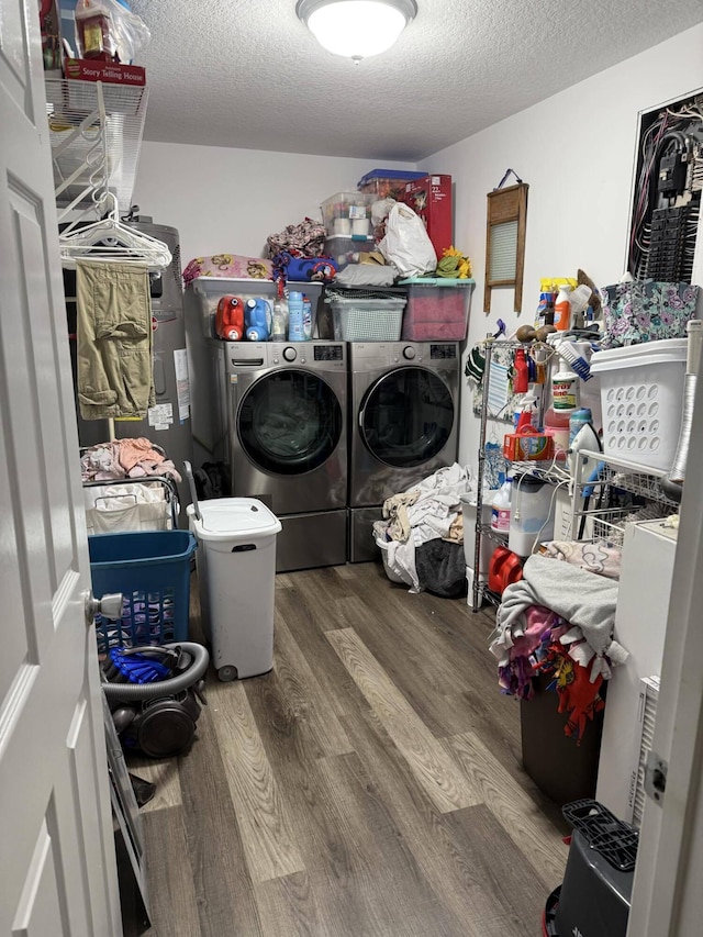 clothes washing area with washer and dryer, wood-type flooring, and a textured ceiling