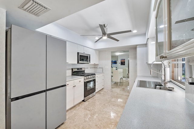 kitchen with ceiling fan, sink, white cabinets, and appliances with stainless steel finishes