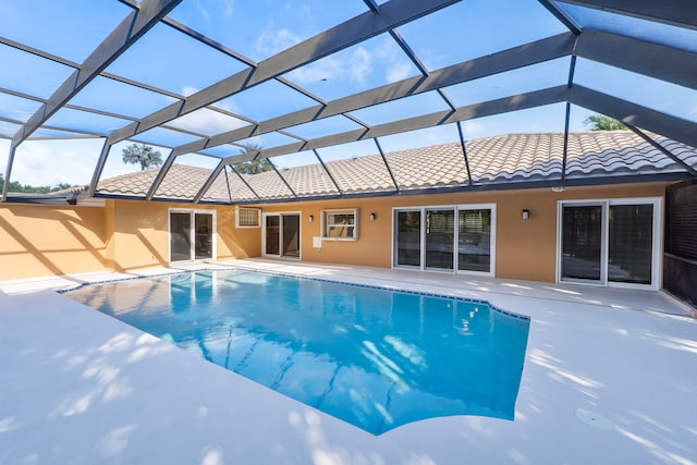 view of swimming pool with glass enclosure and a patio