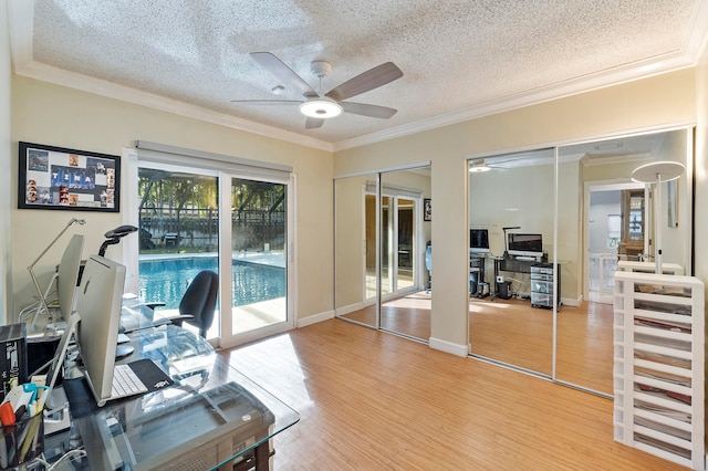 home office with ceiling fan, hardwood / wood-style floors, a textured ceiling, and ornamental molding