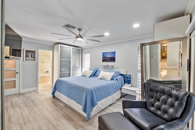 bedroom featuring ceiling fan, light hardwood / wood-style floors, crown molding, and ensuite bath