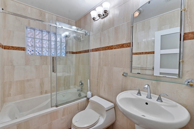 full bathroom featuring toilet, sink, enclosed tub / shower combo, and tile walls