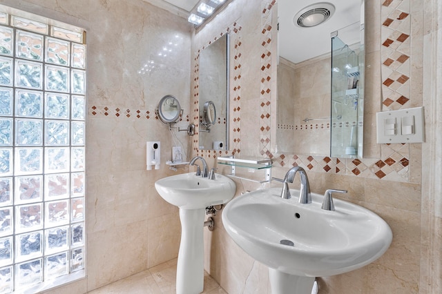 bathroom featuring tile patterned floors, double sink, and tile walls