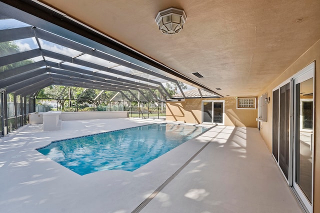 view of swimming pool featuring a patio and a lanai