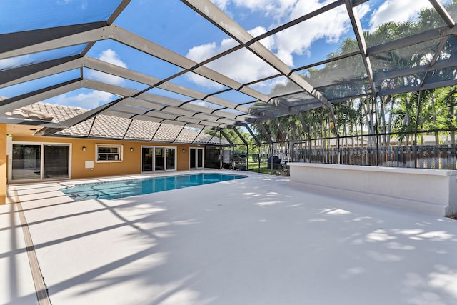 view of swimming pool featuring glass enclosure and a patio area