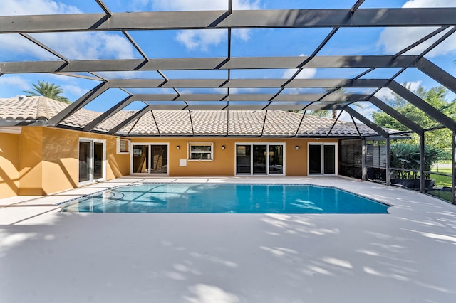 view of pool featuring glass enclosure and a patio area