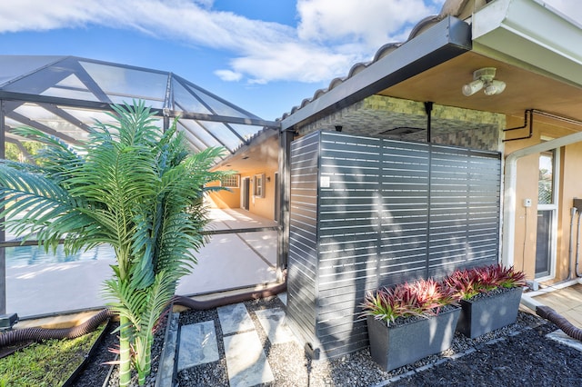 view of side of home with glass enclosure