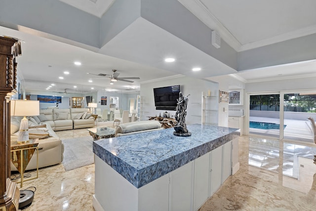 kitchen with a large island, ceiling fan, and ornamental molding