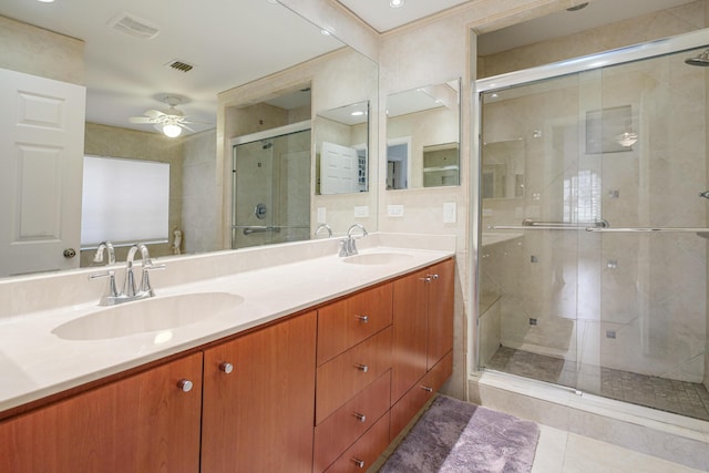 bathroom with ceiling fan, vanity, a shower with door, and tile patterned flooring