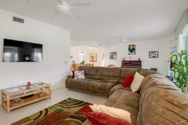 tiled living room featuring ceiling fan with notable chandelier