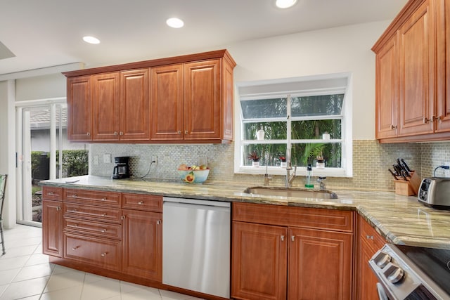 kitchen featuring dishwasher, sink, decorative backsplash, stove, and light tile patterned floors