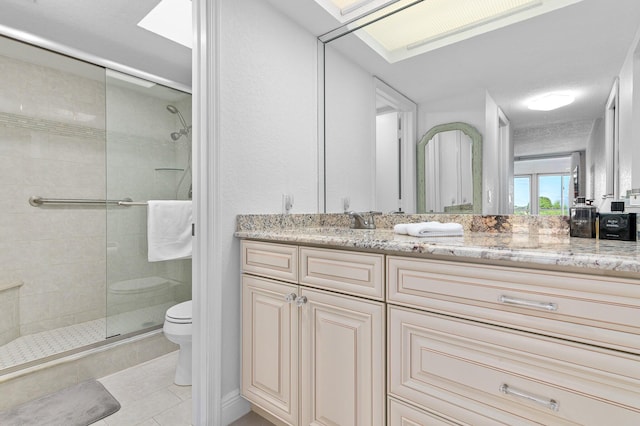 bathroom featuring tile patterned flooring, vanity, toilet, and walk in shower