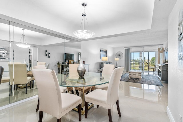 tiled dining room featuring an inviting chandelier