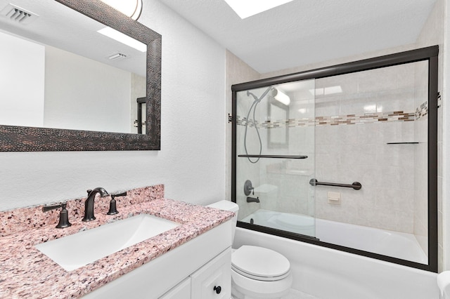 full bathroom with toilet, vanity, a textured ceiling, and combined bath / shower with glass door