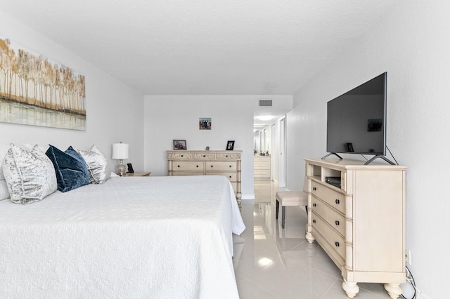 bedroom with light tile patterned floors and a textured ceiling