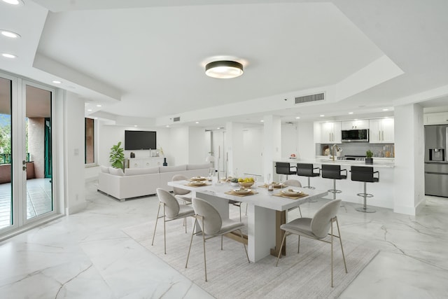 dining space with a tray ceiling and sink