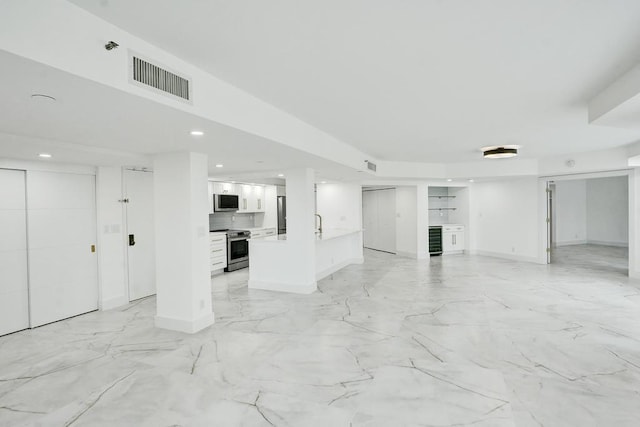 unfurnished living room featuring wine cooler