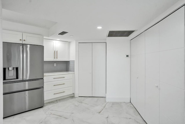 kitchen featuring white cabinets, stainless steel fridge with ice dispenser, and tasteful backsplash