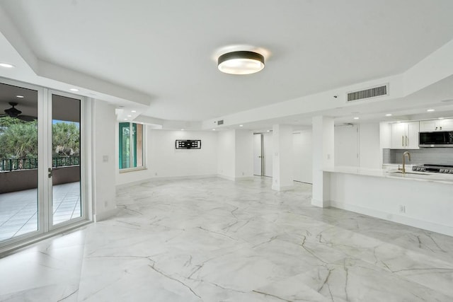 unfurnished living room featuring sink