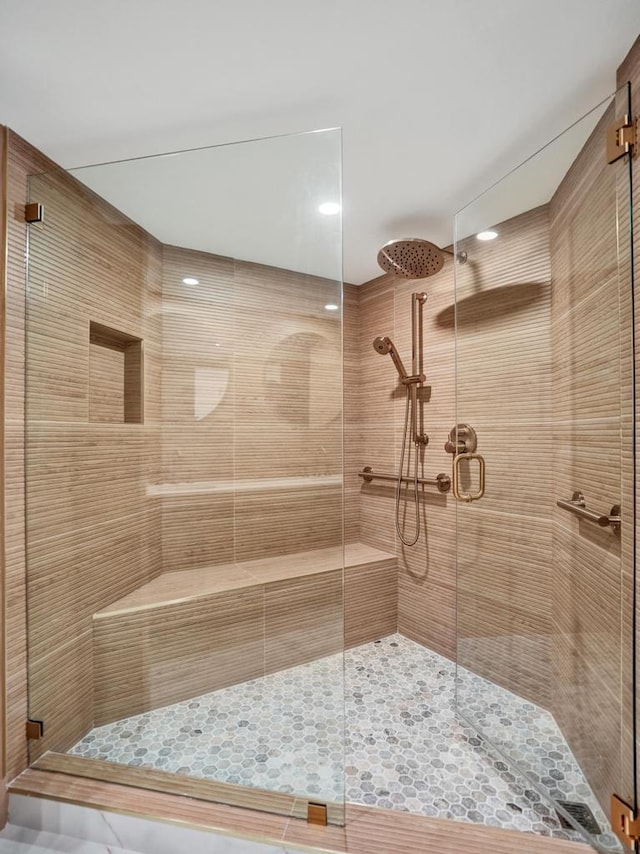 bathroom featuring a shower with door