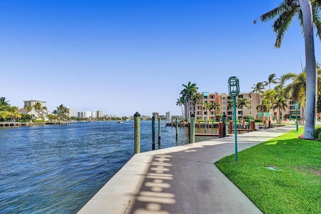 view of dock with a water view and a yard