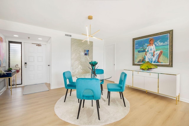 dining room featuring light hardwood / wood-style flooring and a notable chandelier