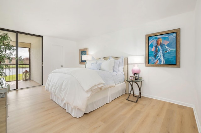 bedroom with access to exterior and light hardwood / wood-style flooring