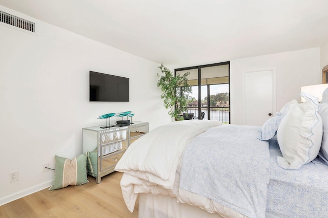 bedroom with access to exterior and wood-type flooring