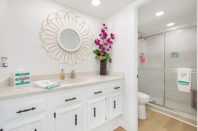 bathroom featuring hardwood / wood-style floors, vanity, toilet, and walk in shower