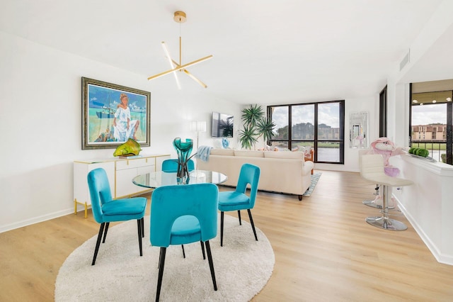 dining space featuring light hardwood / wood-style floors and a notable chandelier