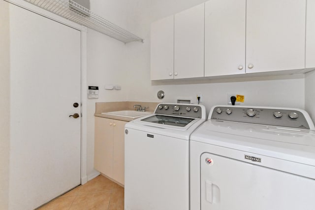 laundry room featuring sink, light tile patterned flooring, cabinets, and independent washer and dryer