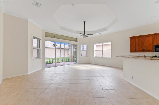 unfurnished living room featuring light tile patterned floors, a raised ceiling, ceiling fan, and crown molding